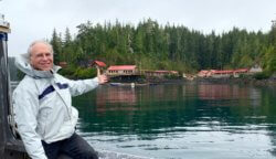 A photo of an older white man gesturing cheerfully to show the bay that could provide sanctuary to Corky the orca