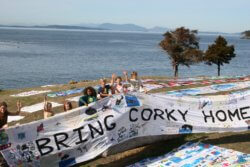 Children hold a section of the mile-and-a-half-long Corky Freedom Banner, which says "Bring Corky Home"